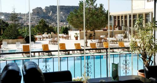 a view of a swimming pool with chairs and tables at Dinler Hotels Urgup in Urgup