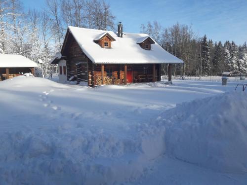 a house covered in snow with a pile of snow at Šumavská Barborka in Vimperk