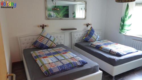 Habitación con 2 camas y espejo. en Ferienwohnung Jungle Adventure, en Günzburg