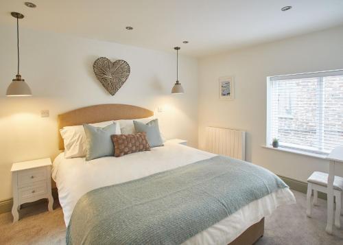 a bedroom with a bed with a heart on the wall at Host & Stay - Threadneedle Cottage in Whitby
