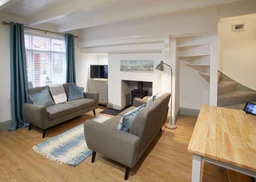 een woonkamer met 2 stoelen en een open haard bij Host & Stay - Threadneedle Cottage in Whitby