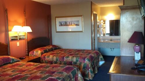 ein Hotelzimmer mit 2 Betten und einem Waschbecken in der Unterkunft Carefree Inn Flatonia in Flatonia