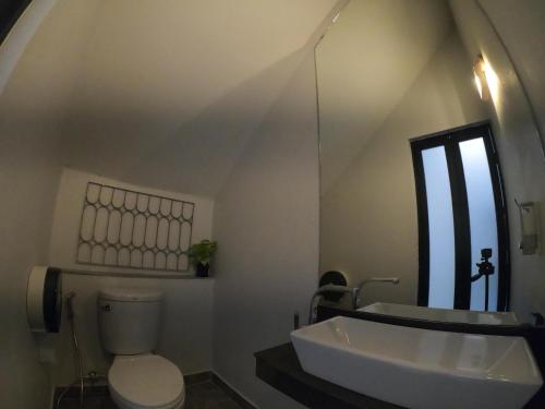 a bathroom with a sink and a toilet and a mirror at Baan Nai Soi Mini Hotel in Chiang Mai