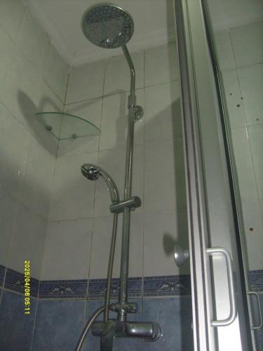 a shower with a glass door with a umbrella at Aznavour room in Casablanca