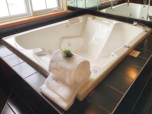 eine Badewanne mit einem Handtuch, das darin sitzt in der Unterkunft Motel La Cheminée in Saint-Jérôme