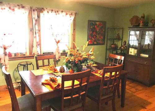 Yellow Door Bed and Breakfast في كريستال بيتش: غرفة طعام مع طاولة خشبية عليها زهور