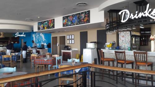 Un restaurante con barra, mesas y sillas. en Sunset 786 Holiday Accom-212, en Strand