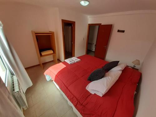 a bedroom with a red bed with two pillows at HOSTERIA DON ATILIO in El Chalten