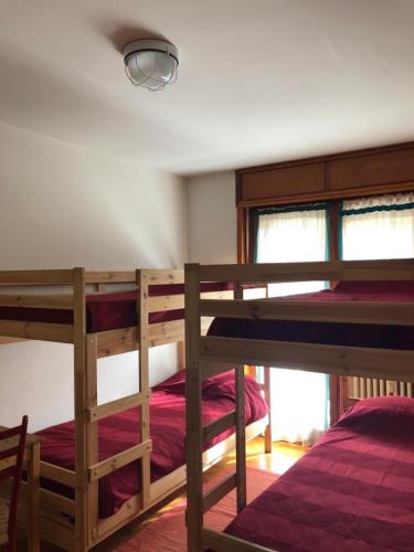 a bedroom with two bunk beds and a window at Appartamento Clotes Sauze d Oulx vicino le piste in Sauze dʼOulx