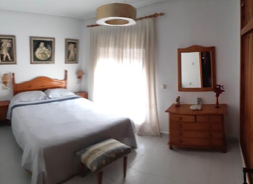 a bedroom with a bed and a mirror and a window at ESPAGNE - ALICANTE - GUARDAMAR DEL SEGURA in Guardamar del Segura