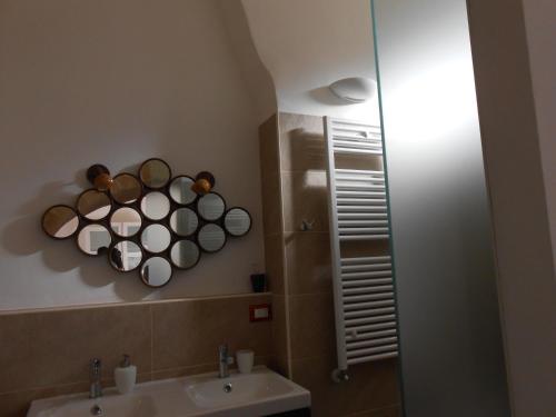 a bathroom with a sink and cups on the wall at Matera's B&B in Matera