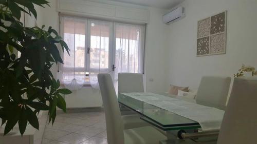 una sala da pranzo con tavolo, sedie e una finestra di Elena’s home a Cagliari