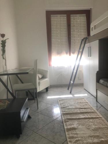 un soggiorno con scala a pioli, scrivania e finestra di Elena’s home a Cagliari