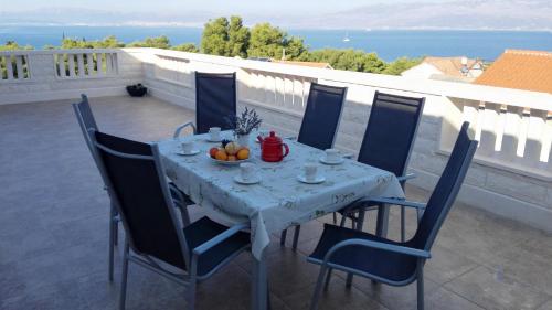 una mesa y sillas en un balcón con vistas al océano en Apartments Marko Sutivan Insel Brać en Sutivan