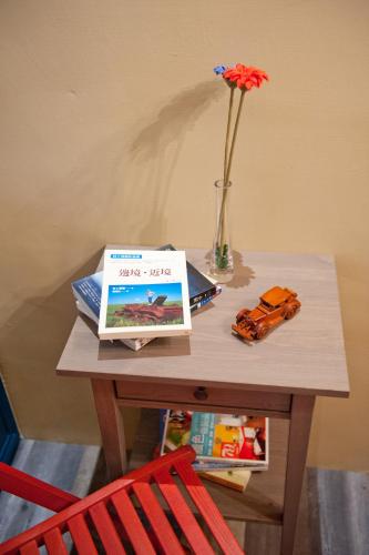 a table with a vase of flowers and a table with a chair at Leo 111/Arena Ruifeng in Kaohsiung