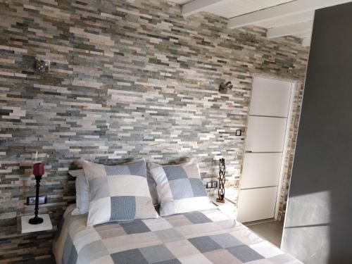 une chambre avec un mur de briques et un lit dans l'établissement Gîte d'Emma, à Lauret