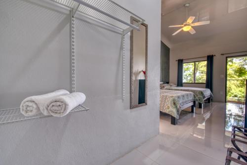a bathroom with towels and a mirror and two beds at Hotel Casa Conley Del Mar in Puerto Viejo