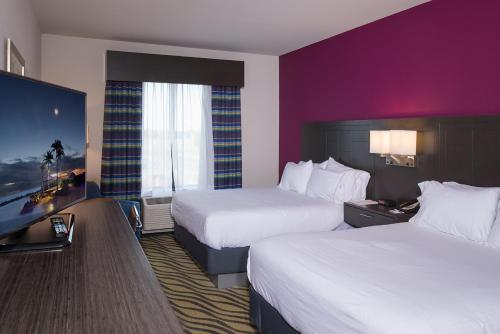 a hotel room with two beds and a desk at Holiday Inn Express Hutchison by IHG in Hutchinson
