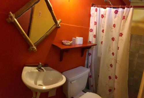 a bathroom with a sink and a toilet and a mirror at Hostal Surf Olón in Olón