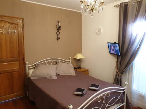 Un dormitorio con una cama y una lámpara de araña. en REDHOUSE Chambre zen, en Roques Sur Garonne
