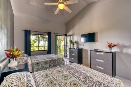 a bedroom with two beds and a ceiling fan at Hotel Casa Conley Del Mar in Puerto Viejo