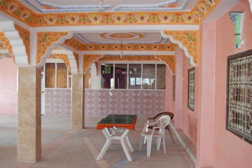 a room with a table and chairs and a ceiling at Auberge Tafilalt Bouzmou Bouzmou in Imilchil