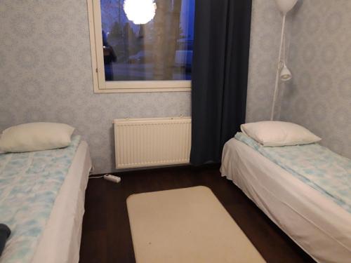 Cette petite chambre comprend 2 lits et une fenêtre. dans l'établissement Pulmustie 19as2 Huoneisto, à Ylivieska