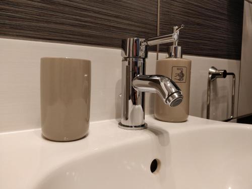 um lavatório com uma torneira e um copo sobre ele em Gîte d'Emma em Lauret