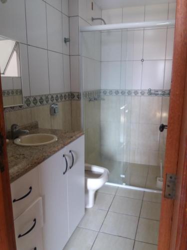 a bathroom with a shower and a sink and a toilet at Ed. Praia de Palmas SC in Governador Celso Ramos
