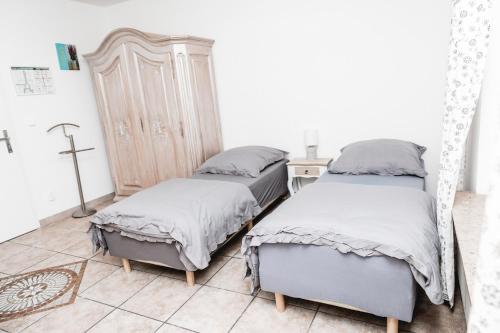a bedroom with two beds and a dresser at Feierabend Elsdorf in Elsdorf