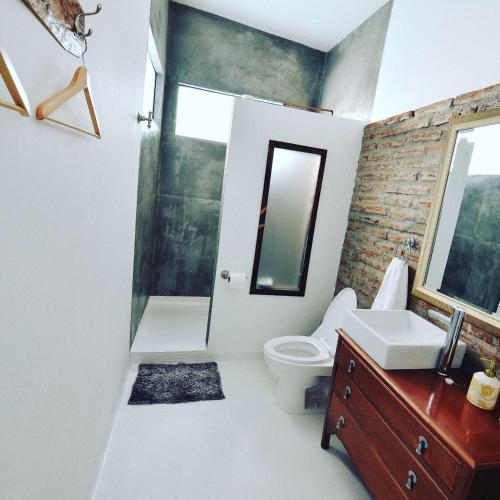 a bathroom with a toilet and a sink and a mirror at Rincón del Corazón in Valle de Guadalupe