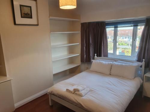 Un pequeño dormitorio con una cama con toallas. en Elegant house 10 minutes walk to wembley stadium en Londres