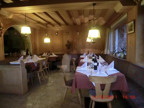 a dining room with tables and chairs and lights at Albergo Somont in Ortisei