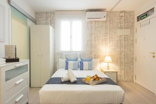 um quarto com uma cama com uma bandeja de frutas em Ronda de Valencia apartamento em Madri