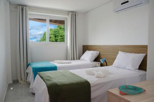 deux lits dans une chambre avec fenêtre dans l'établissement Makaiba Residence 203, à Porto de Galinhas