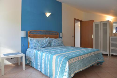 a bedroom with a bed with a blue wall at Casa Maja in Santa Maria di Castellabate