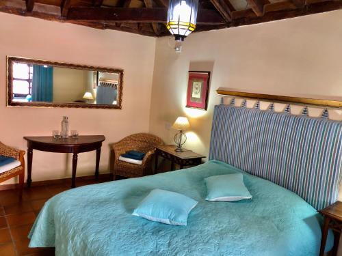 a bedroom with a bed with a mirror and a table at Hotel Rural Vilaflor Self check in 24h in Vilaflor