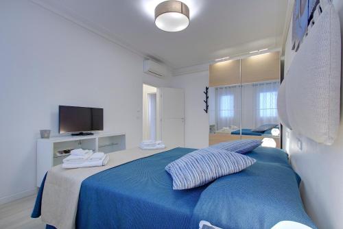 - une chambre avec un lit bleu et une télévision dans l'établissement RECIOTO Rialto-Market, à Venise