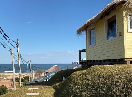 a house on a hill next to the beach at Cabañas Punta Papaya in Punta Del Diablo