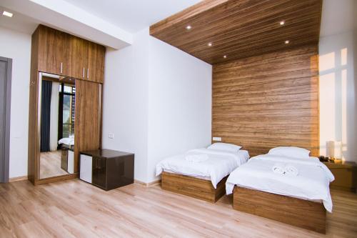 a bedroom with two beds and a mirror at Victoria Inn Tbilisi in Tbilisi City