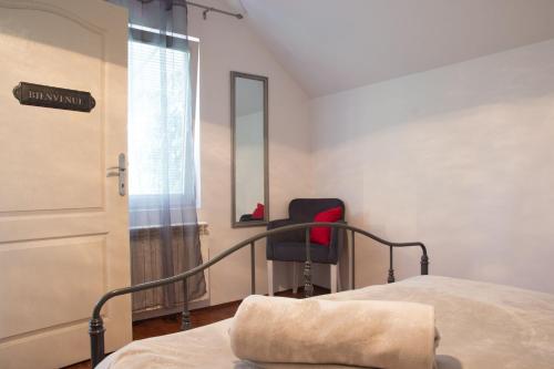 a bedroom with a bed and a chair next to a door at Dolce Casa in Belgrade