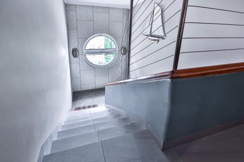 a bathroom with a staircase with a round window at Kamienica Morska Gdynia in Gdynia