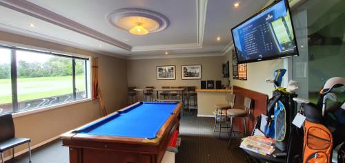 a room with a pool table and a flat screen tv at Maxwell's Golf Retreat in Bombay