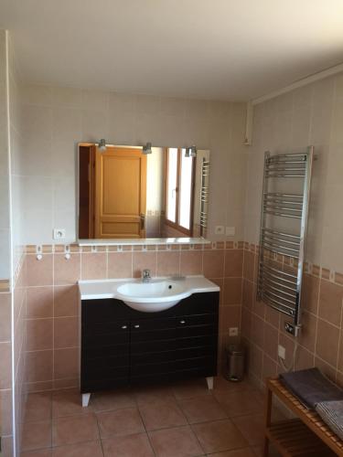 uma casa de banho com um lavatório e um espelho em La soulane em Ax-les-Thermes