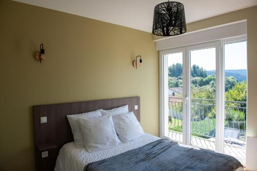 une chambre avec un lit et une grande fenêtre dans l'établissement Entre Montagne et lac, à Gérardmer