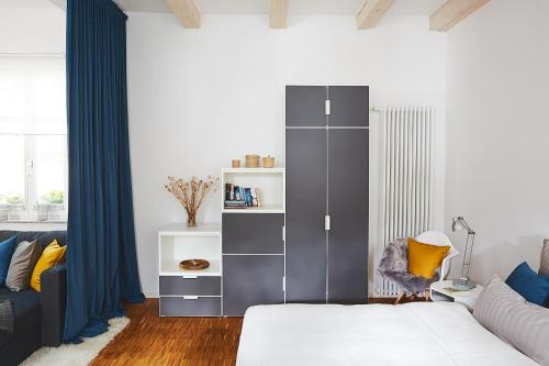 Un dormitorio con un gran armario gris y un sofá en Altstadtloft Teltow, en Teltow