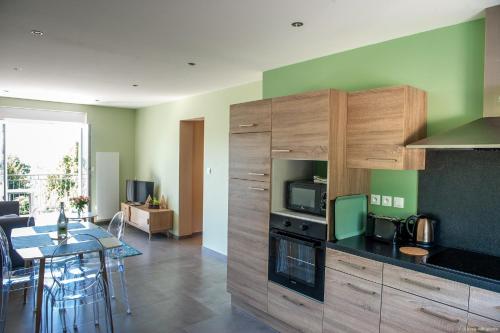 Il comprend une cuisine et un salon avec une table et un four micro-ondes. dans l'établissement Entre Montagne et lac, à Gérardmer