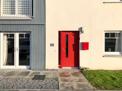 a red door on the side of a building at Ventoux in Aviemore