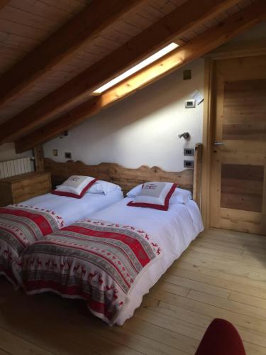 a bedroom with two beds with red and white blankets at LTHorses & Dreams in La Thuile