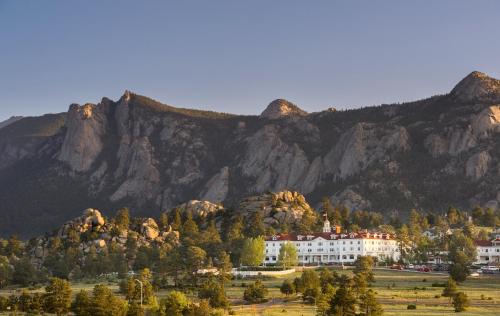 a building in front of a mountain with trees at The Stanley Hotel in Estes Park